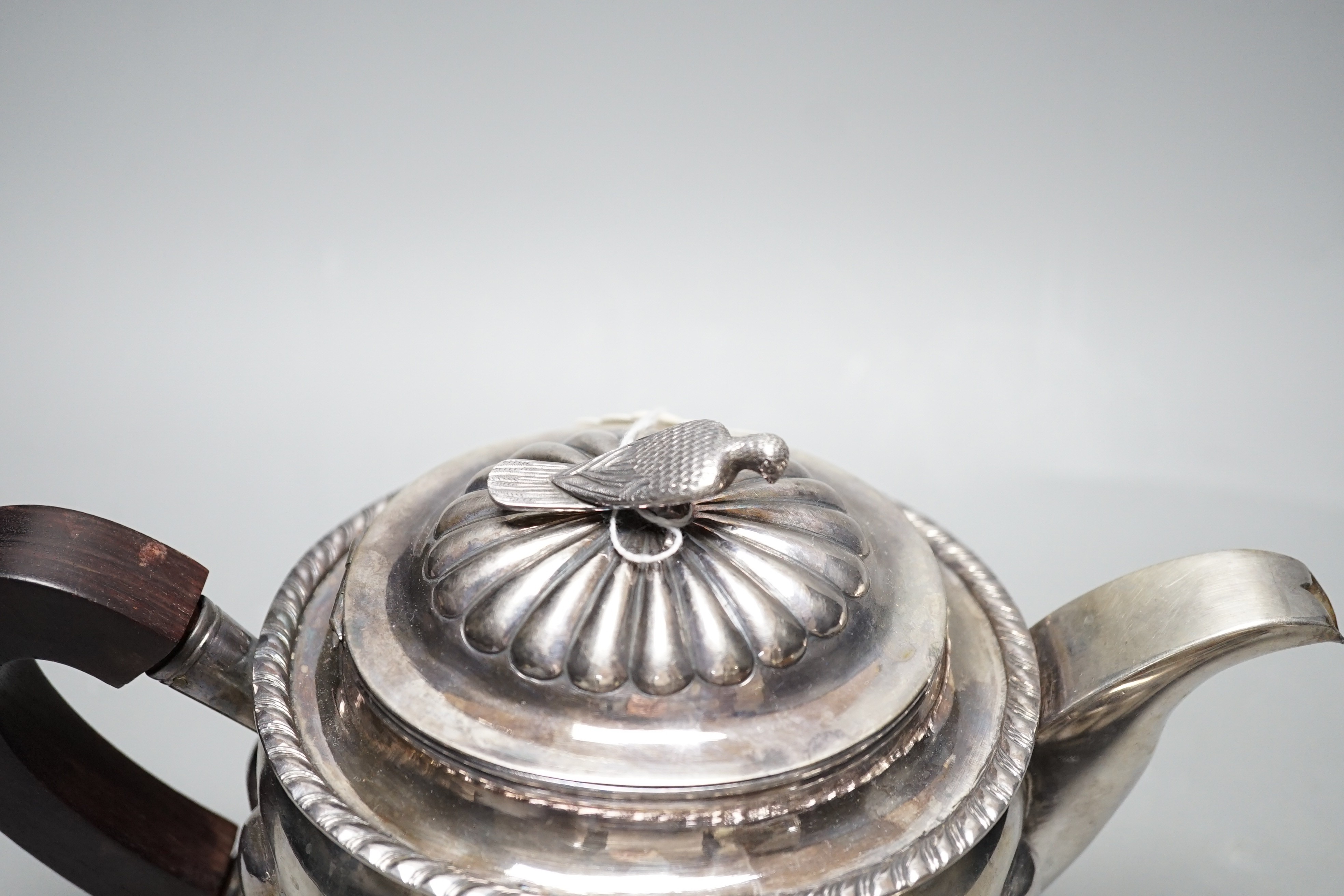 A Chinese Straits? demi fluted white metal teapot and cream jug, with rosewood handles and bird finial, maker TAI, gross weight 31.5oz.